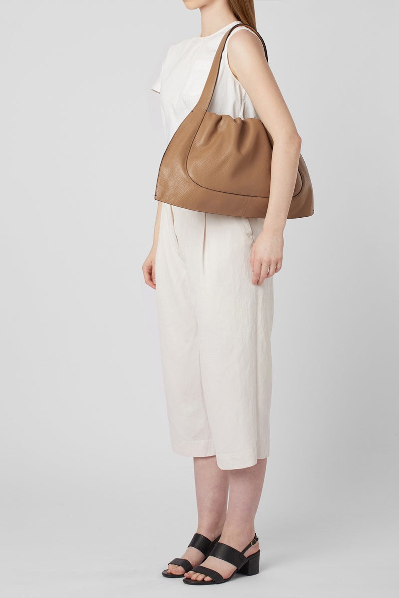 Large almond-colored pebble leather ANA tote shoulder bag by behno New York shown on model.