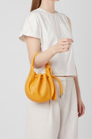Behno New York INA Mini Crossbody Nappa Pollen top handle bag with sleek design and vibrant yellow color.