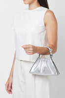 Silver metallic Baguette Mini Top Handle Bag by behno New York with ruched saffiano leather, worn on body for a stylish look.