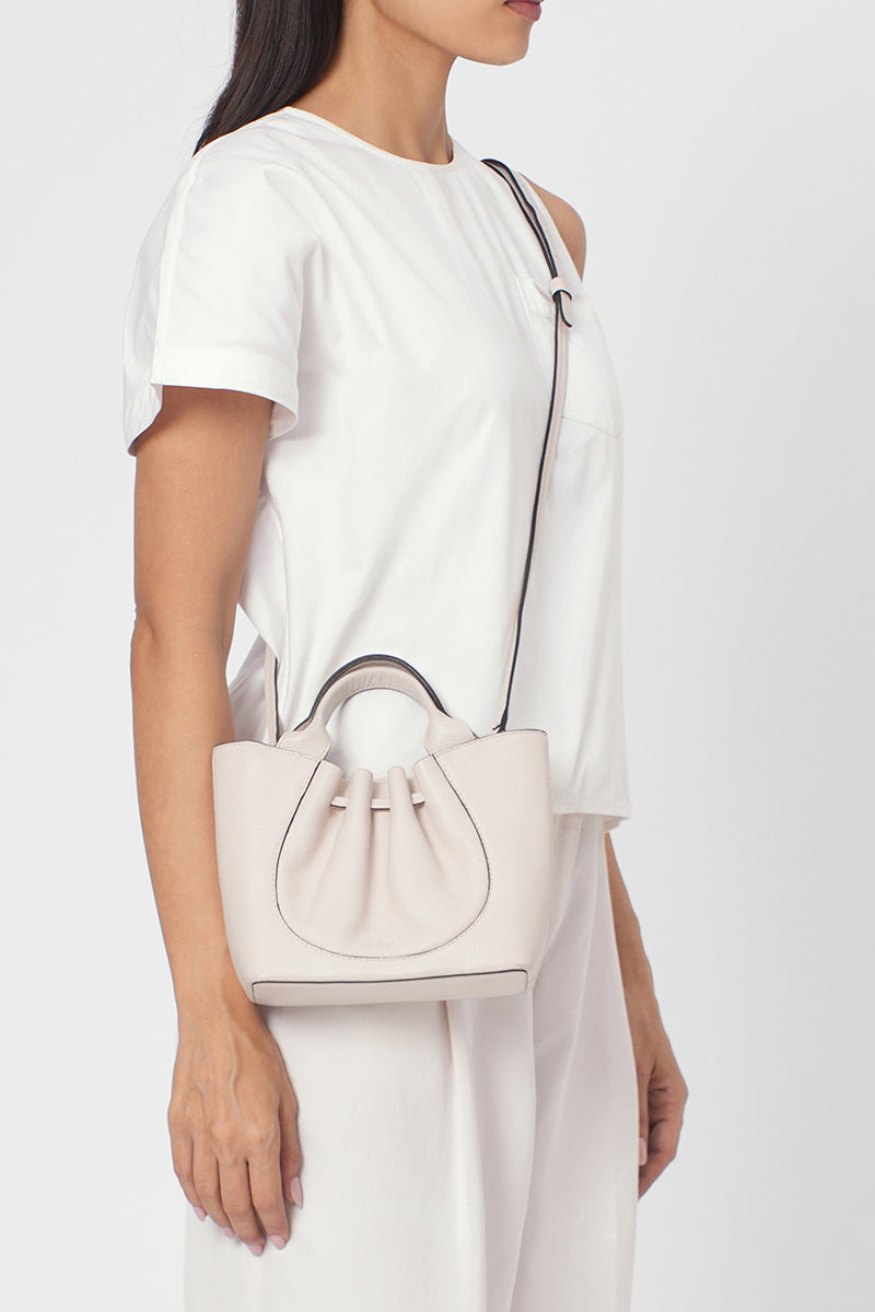 Behnō New York Katrina Mini Tote Pebble in Pumice shoulder bag with soft pebble texture, worn on body for casual style.