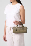 Behnø New York Michelle mini crossbody bag in nappa palm leather with top handle, shown on model's body.