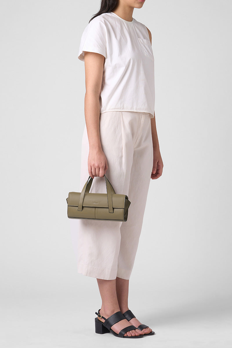 Behnio New York Michelle mini crossbody bag in nappa palm leather, shown on body with top handle style and textured surface.