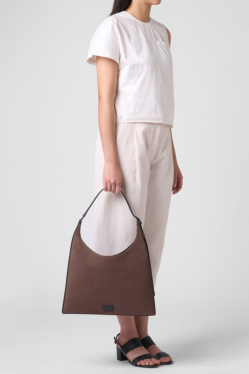 Large canvas Danny flatiron shoulder bag in cacao and black, featuring a spacious design and durable handles by behno New York.