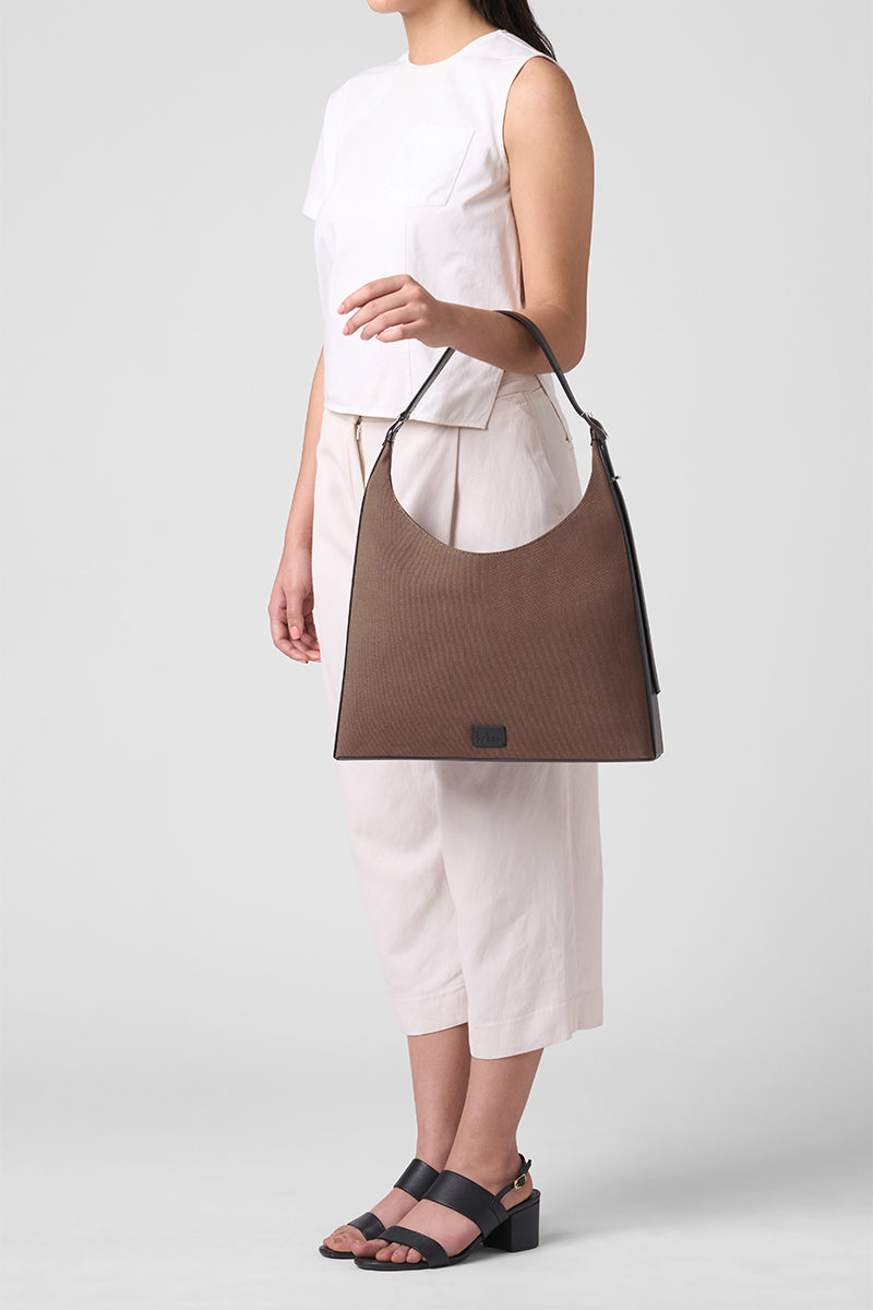 Large canvas shoulder bag by behno New York in cacao and black, featuring a sleek, spacious design with a comfortable shoulder strap.