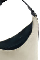 Large canvas shoulder bag in sand and black by behno New York, featuring a sleek flatiron bag design with detailed stitching.