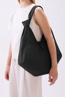 Large black Nelli Hobo pebble shoulder bag by behno New York shown on a model, highlighting its slouchy shape and textured leather.