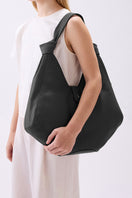 Black Nelli Hobo Large Pebble shoulder bag by behno New York, shown on body with a sleek, textured pebble leather finish.