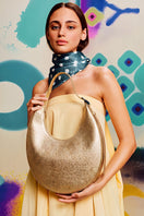 Medium metallic gold shoulder bag by behno New York featuring a sleek crescent shape and stylish design.