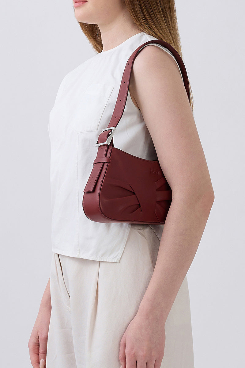 Behn New York Leena Mini Shoulder Bag in brick-colored nappa leather with draped design and compact silhouette.
