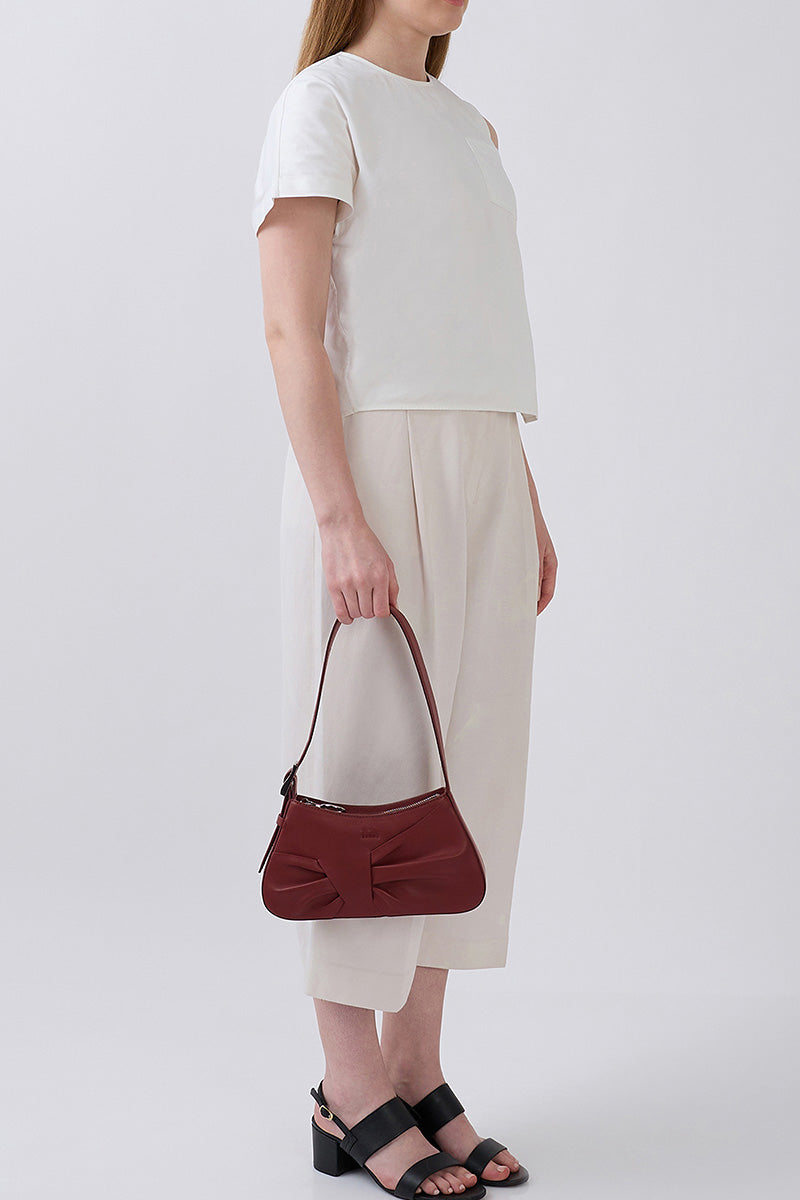 Behn New York Leena Mini Shoulder Bag in brick-colored nappa leather with draped design and compact style.