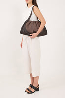 Large Behno New York ANA tote shoulder bag in cacao and black canvas, shown on a person wearing it.