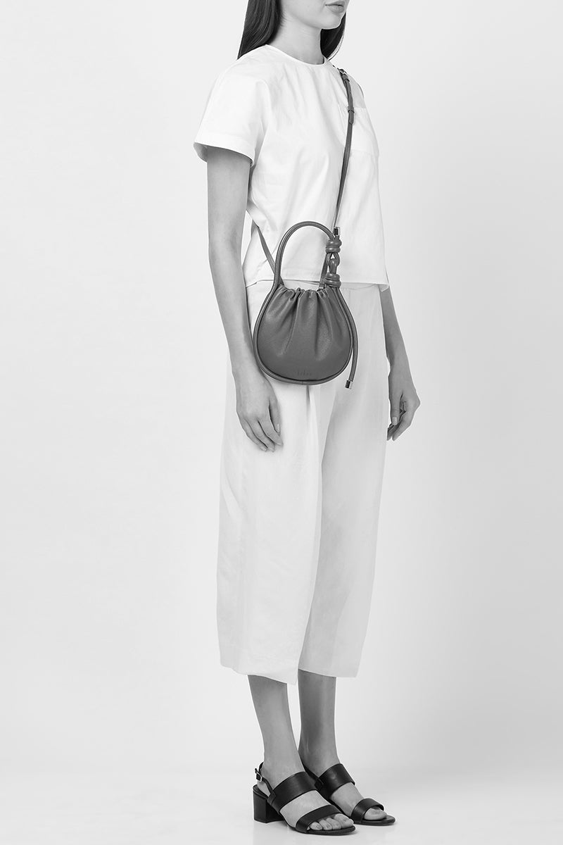 Behno New York INA Mini Potli Nappa Brick top handle bag with a structured design and elegant brick color.