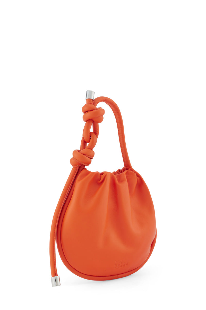Behno New York INA MINI POTLI NAPPA CARROT top handle bag with vibrant orange leather and elegant design.