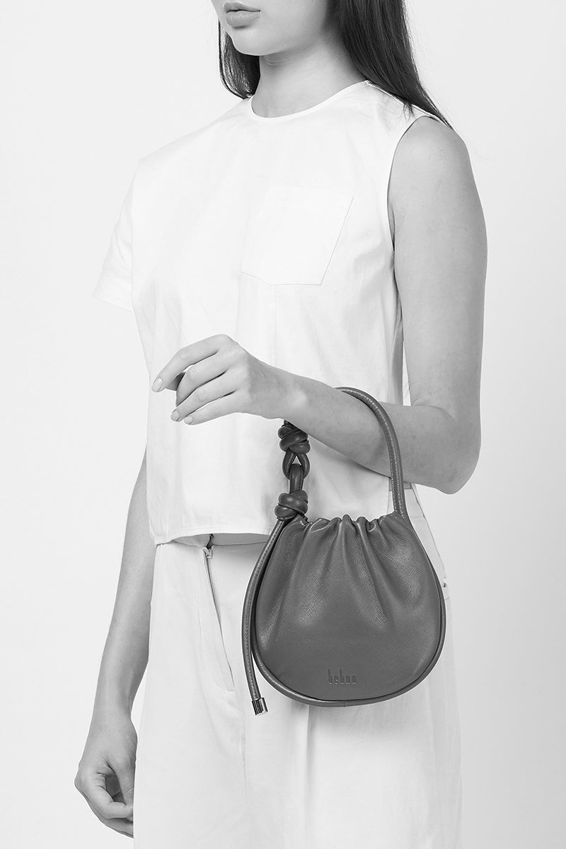 Behno New York INA Mini Potli Nappa Carrot top handle bag with vibrant orange color and compact design.