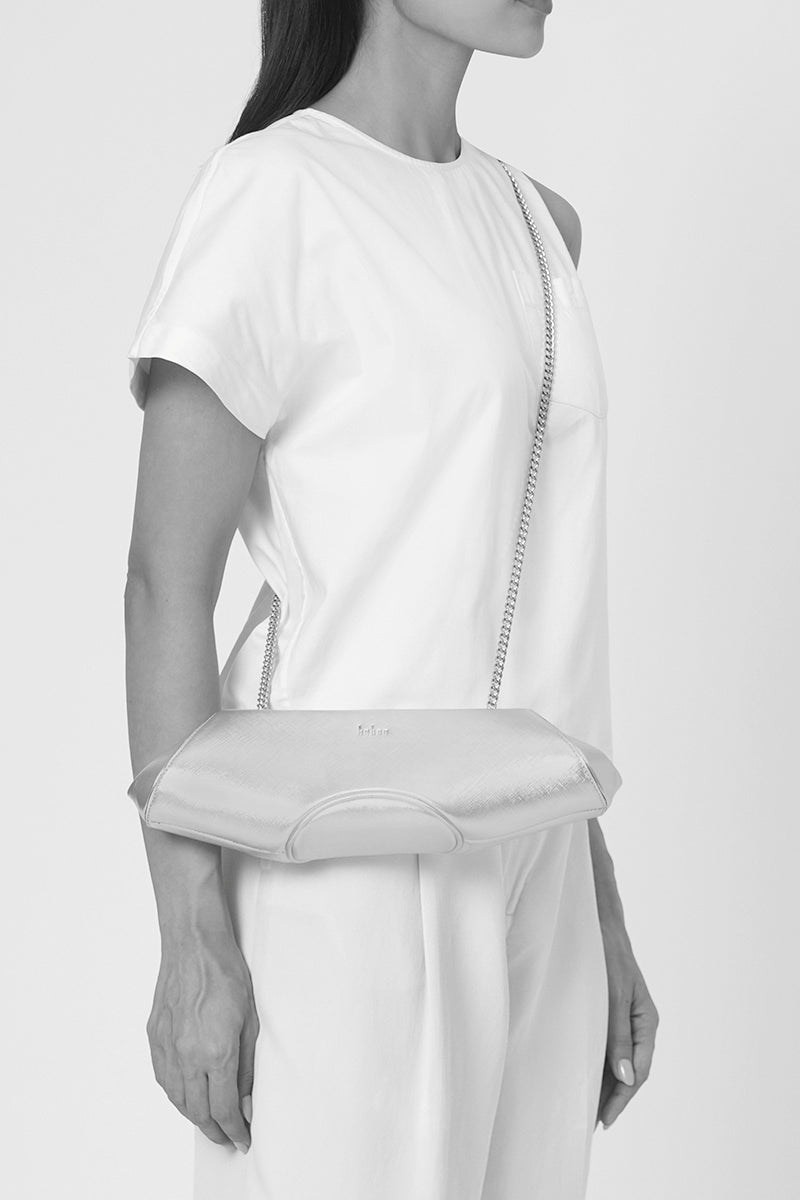 Gold Elizabeth Baguette Mini Clutch by behno New York, featuring a sleek design and compact size, shown on body.