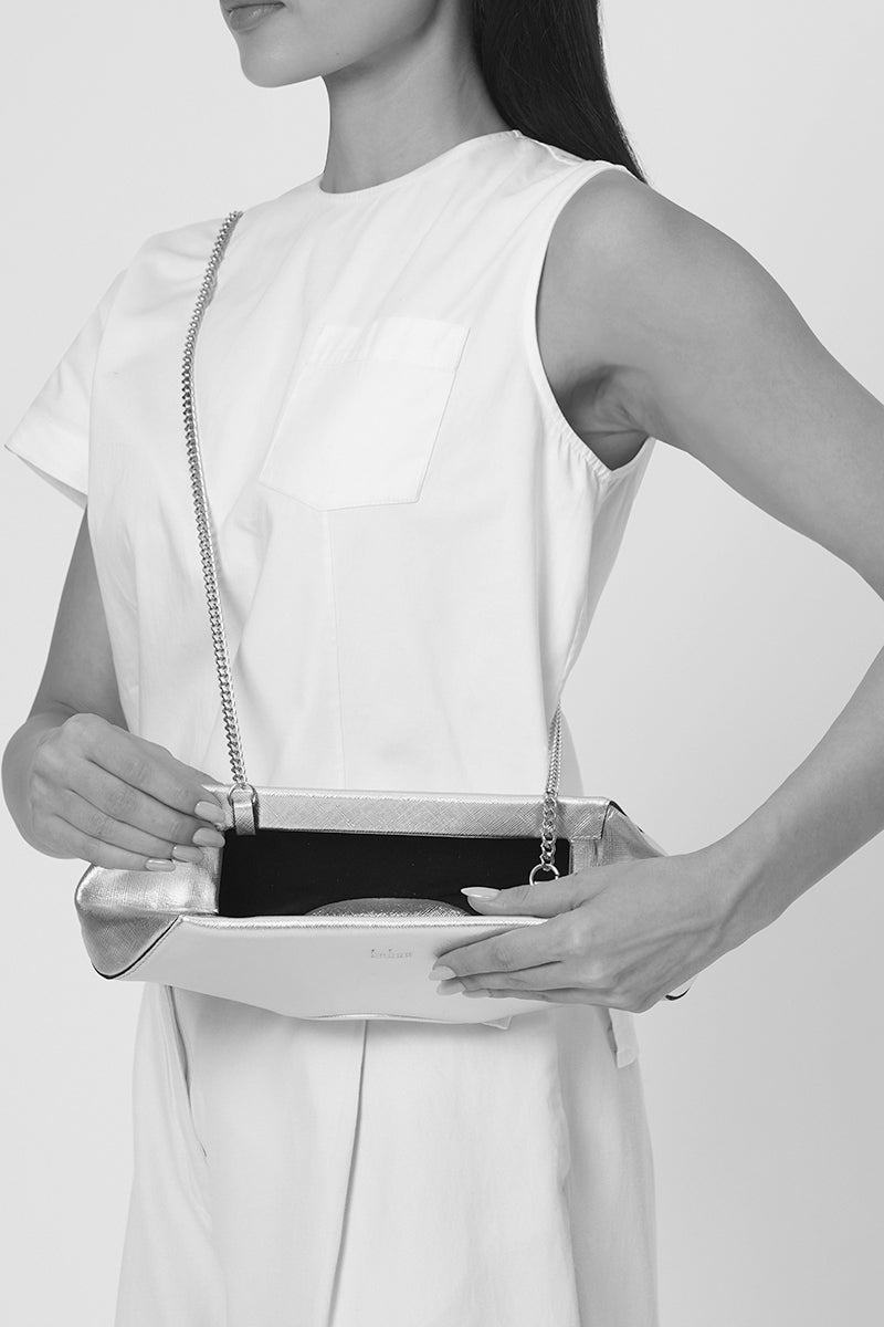 Behn New York Elizabeth Baguette Mini Clutch in gold with sleek design and compact shape, worn as a stylish accessory.