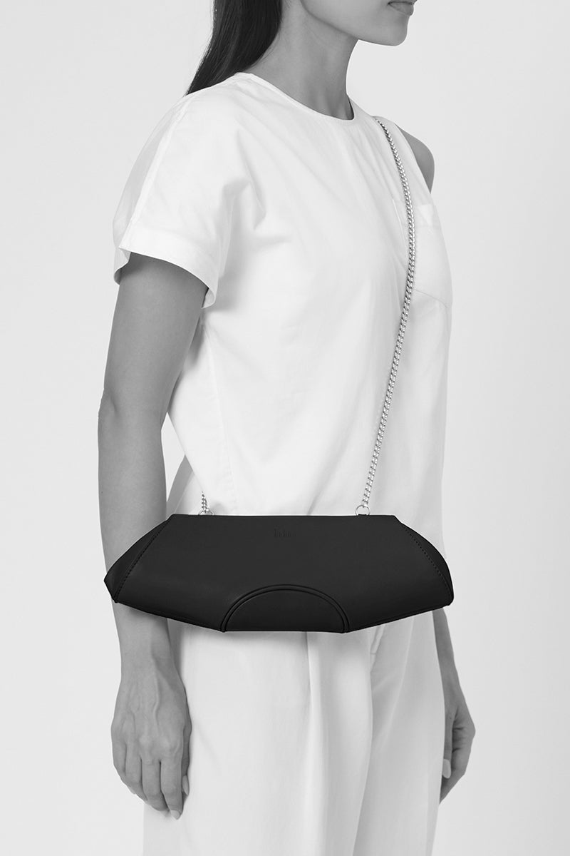 Behno New York Elizabeth Baguette Mini Clutch in hematite with sleek metallic finish, shown on model.