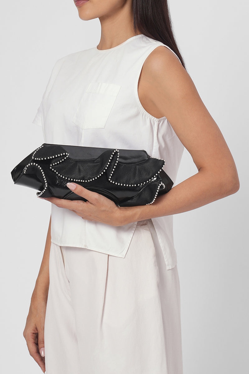 Black Elizabeth Baguette Mini Clutch by behno New York with ruffle silk and crinkle design, casual on-body shot.