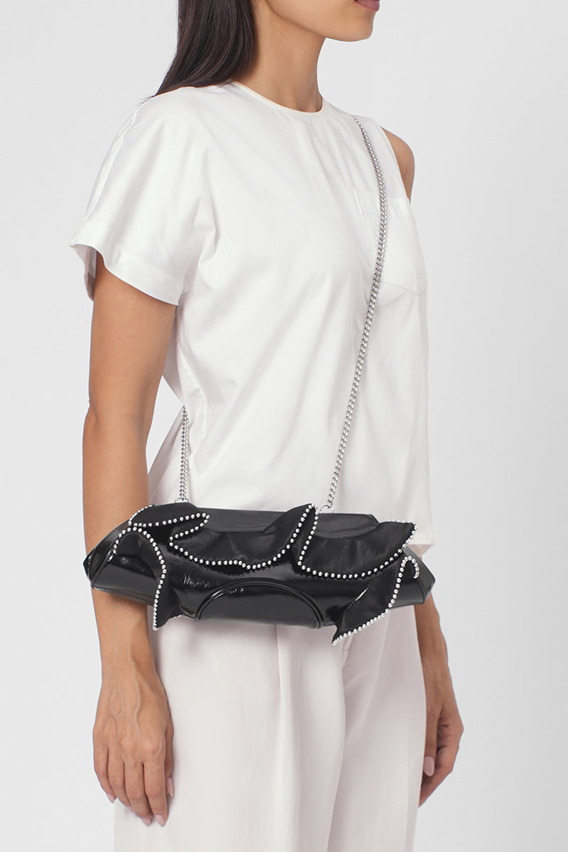 Black Elizabeth Baguette Mini Clutch by Behno New York with ruffle silk and crinkle texture, on-body shot.