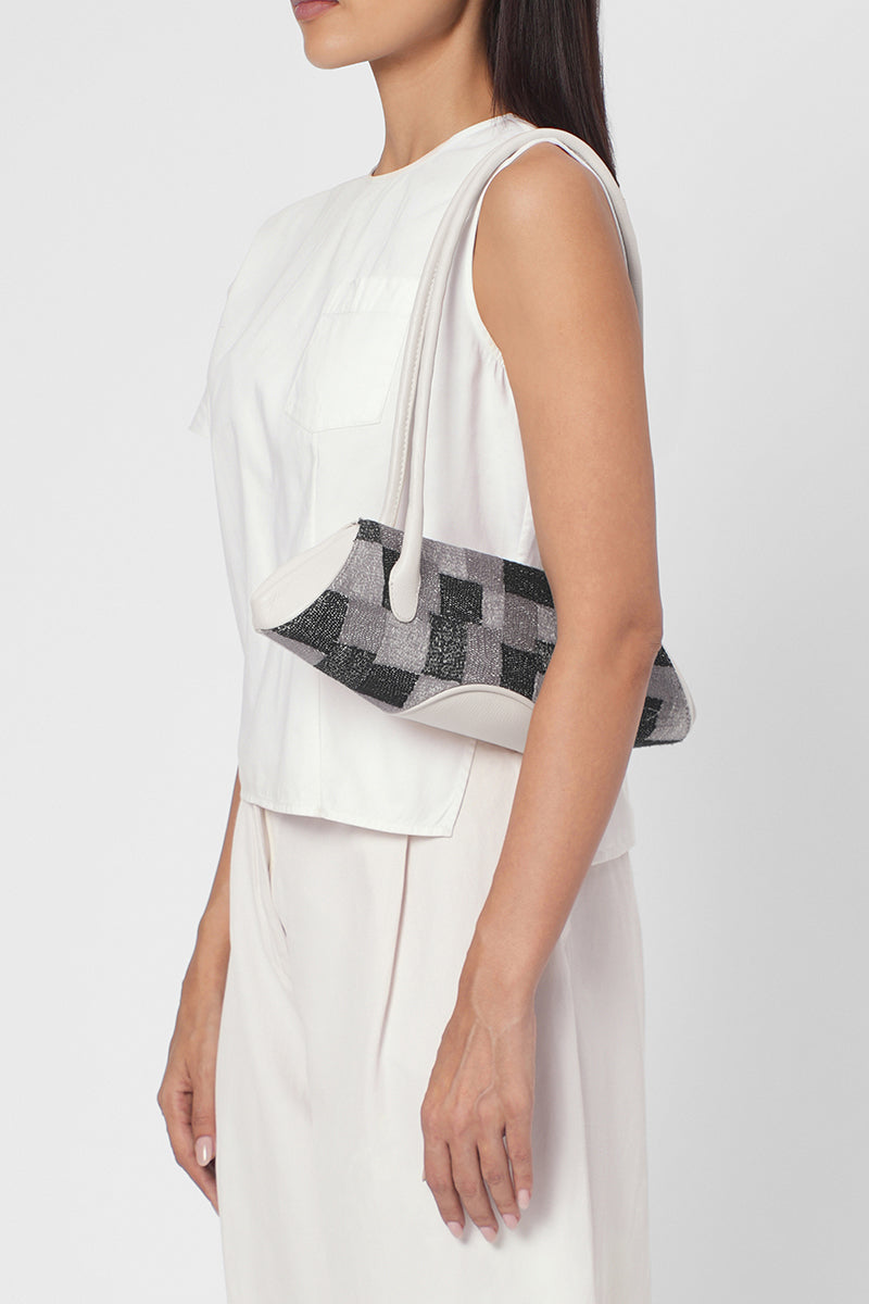 Behnon New York Elizabeth Baguette Mini top handle bag in Pumice with Kantha silk and pebble detailing, worn on shoulder.