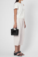 Black Katrina Mini Tote No2 crinkle shoulder bag by behno New York, showing its textured fabric and compact design on a model.