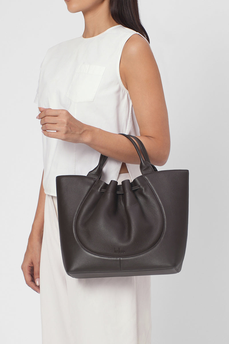 Behn New York Katrina satchel shoulder bag in cacao leather, shown on body with strap and spacious interior visible.