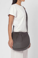 Nilde Hobo shoulder bag by behno New York in milled cacao leather, shown on body with strap and sleek design.