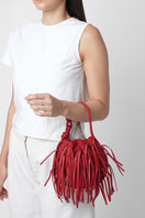 Red INA Mini Potli Fringe Nappa top handle bag by behno New York, shown with on-body view highlighting its fringe details.