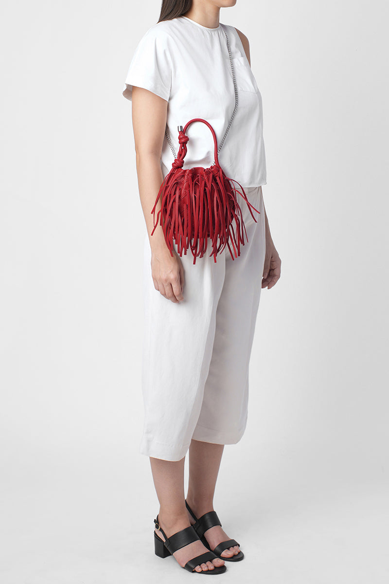 Red INA mini potli fringe nappa top handle bag by behno New York, featuring a stylish fringe design on smooth leather.