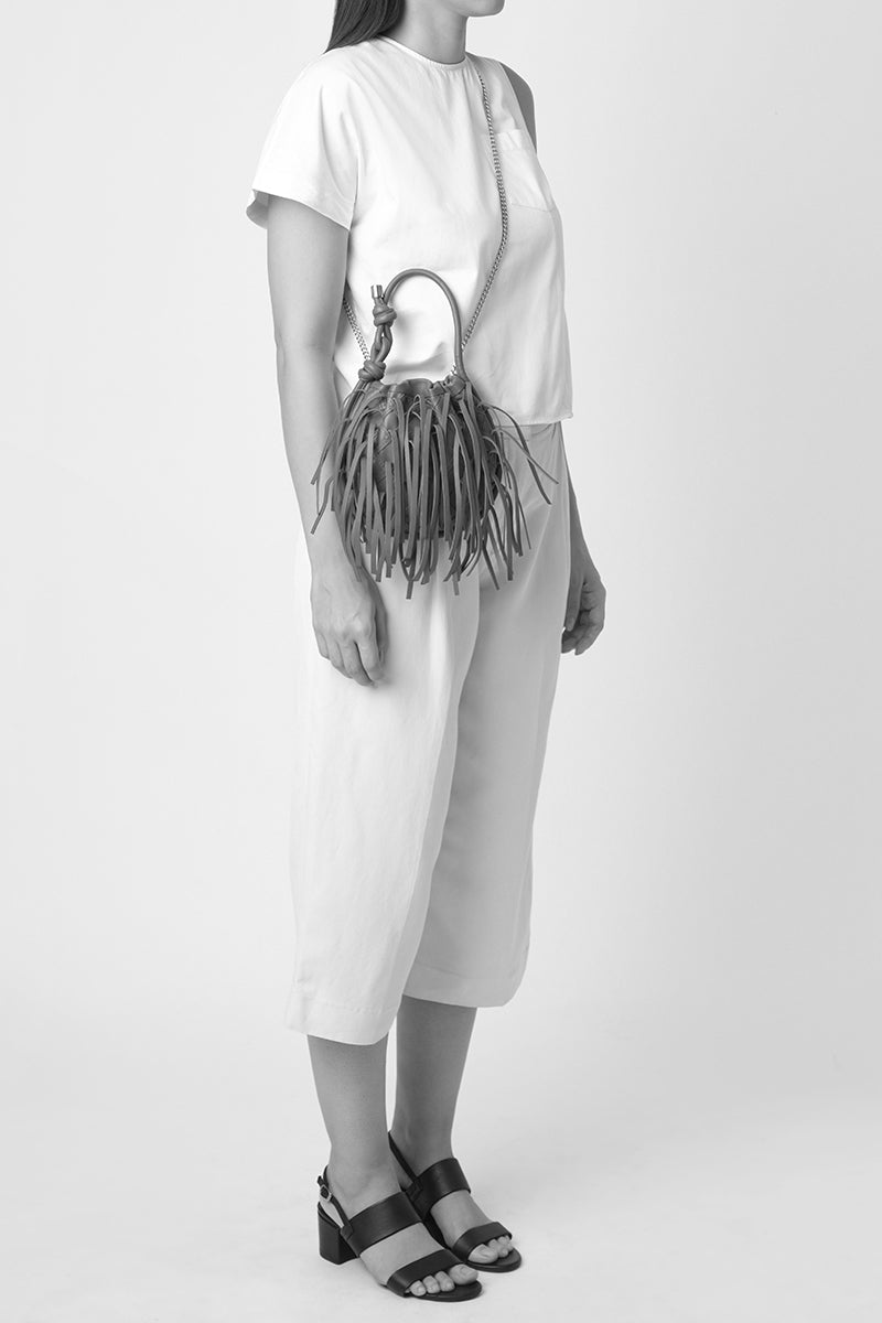 Silver INA Mini Potli fringe crinkle top handle bag by Behno New York, featuring a stylish on-body view with fringe details.