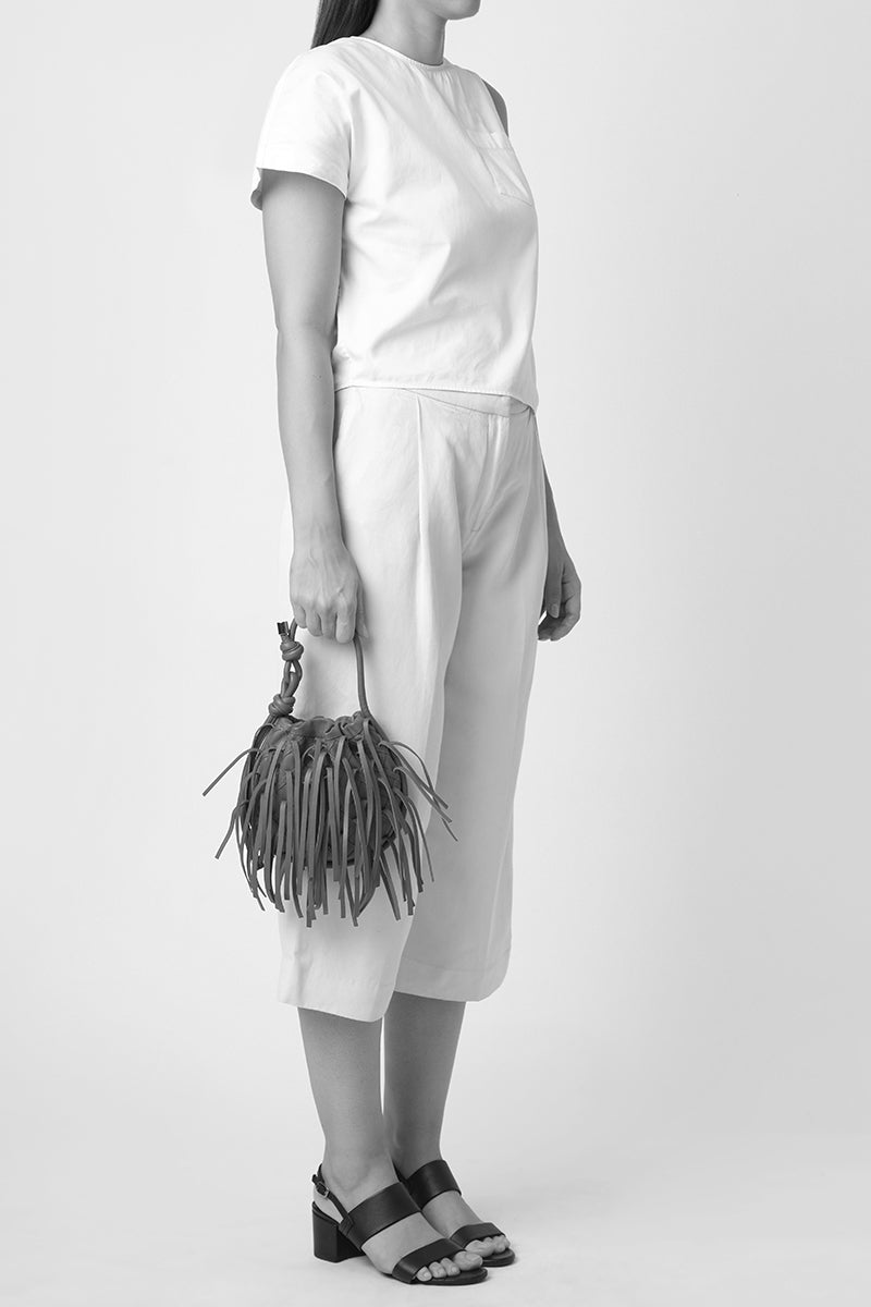 Silver INA Mini Potli Fringe Crinkle top handle bag by behno New York, showcasing its textured crinkle fabric and decorative fringe.