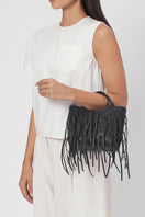 Black Katrina Mini Tote No2 Fringe Nappa shoulder bag by behno New York with fringe details, worn on model in on-body view.