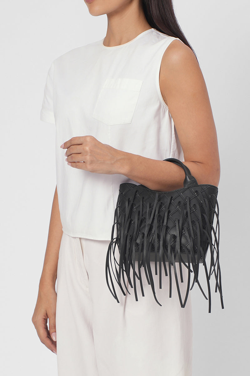 Black Katrina Mini Tote No2 Fringe Nappa shoulder bag by behno New York with fringe details, worn on model in on-body view.