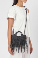 Black Katrina Mini Tote No2 Fringe Nappa shoulder bag by behno New York, shown on body with fringe details and sleek design.