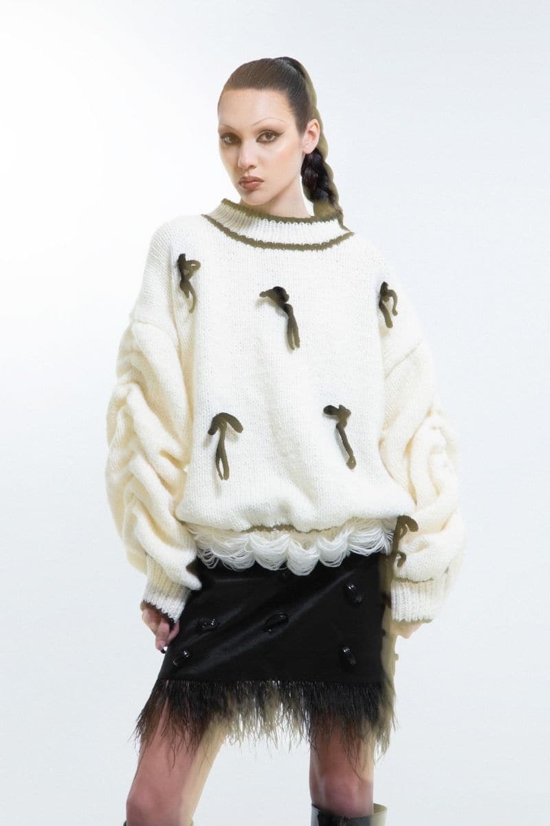 Cream-colored Blikvanger knitted sweater featuring a cake pattern, cozy and stylish, worn by a model.