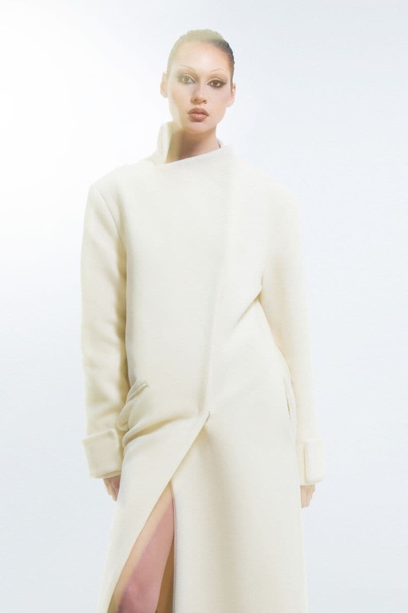 Milky white long coat by Blikvanger, featuring a sleek, elegant design with a tailored fit and classic collar in soft white fabric.