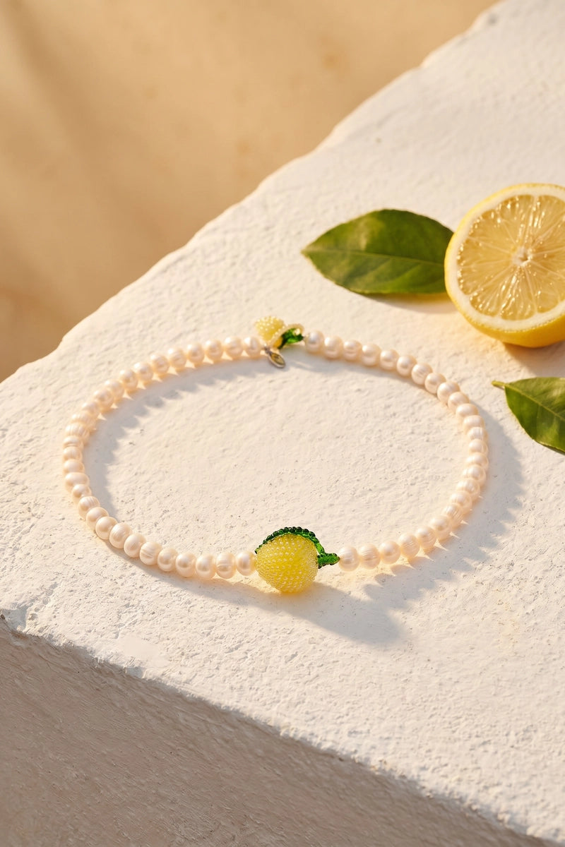Pura Utz Pearl Lemon Necklace featuring a string of pearl and lemon-shaped beads on a delicate chain.