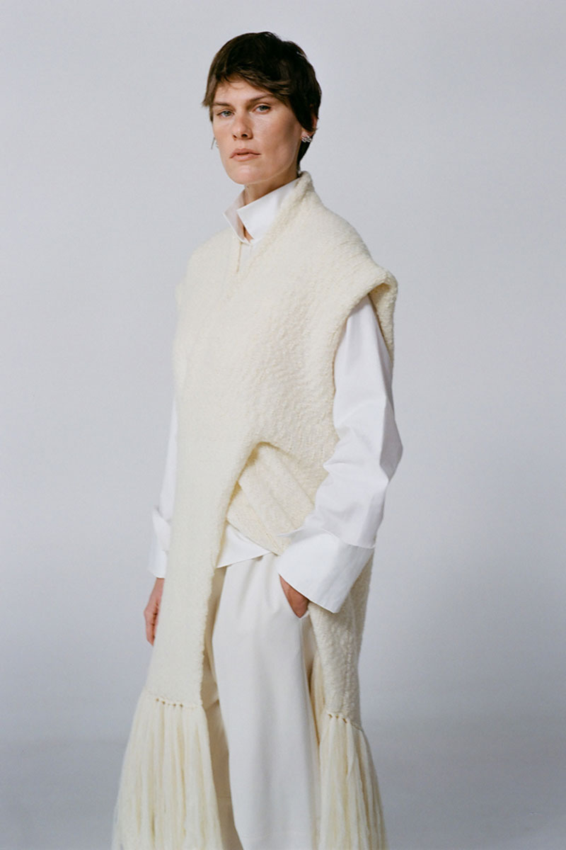 Textured knit cardigan vest by DELEGAN featuring a cozy, patterned design displayed in a campaign photo.