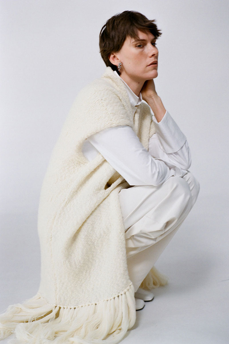Textured knit vest cardigan by DELEGAN, shown in a campaign image, featuring a cozy, ribbed design and stylish fit.