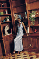 Blue pleated V-neck evening gown by Aisl, flowing fabric with elegant pleats perfect for formal occasions.