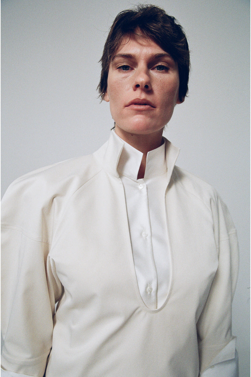 Gray-beige structured shirt by DELEGAN, featuring a tailored fit and modern design, displayed in a fashion campaign image.
