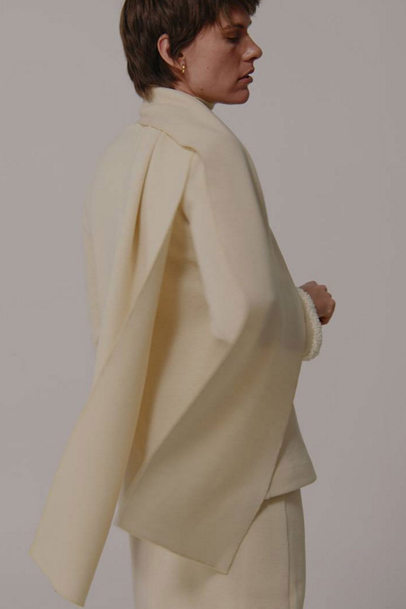 Delegen wool sweater, cozy knit with a classic design, shown on a model in a casual outdoor setting.
