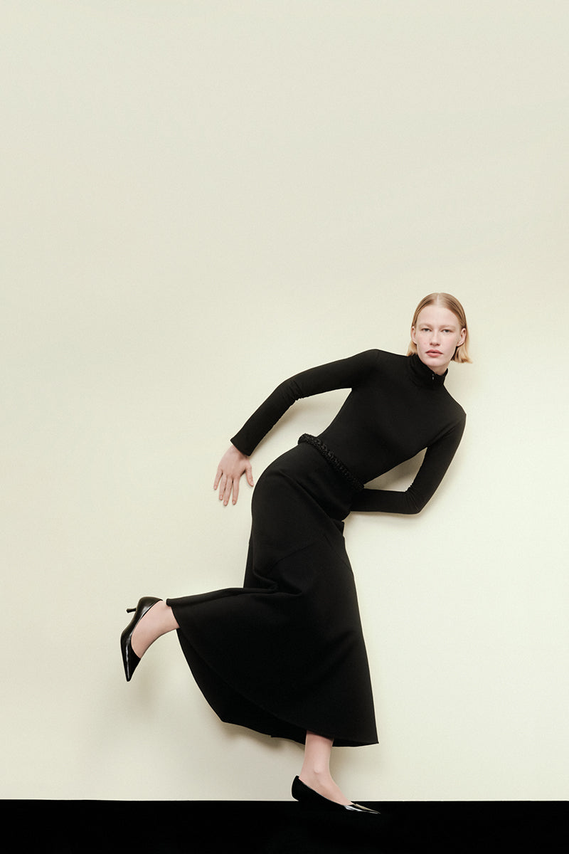 Black midi skirt from DELEGAN KOSSA collection, featuring a sleek design and fitted waist, perfect for stylish everyday wear.