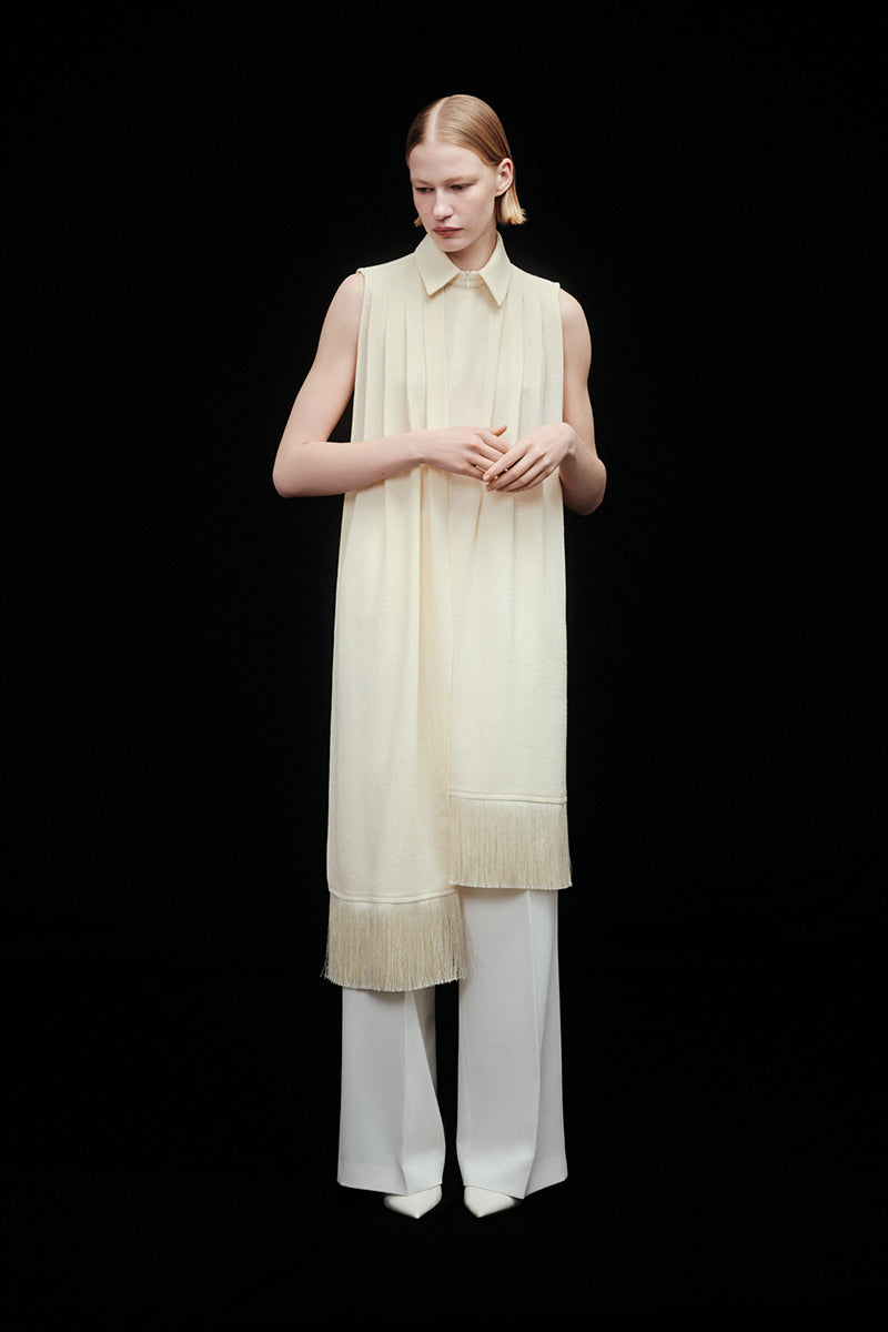 Warm ivory shirt scarf with silk fringe by DELEGAN, draped neatly showing its soft fabric and elegant fringe detailing.