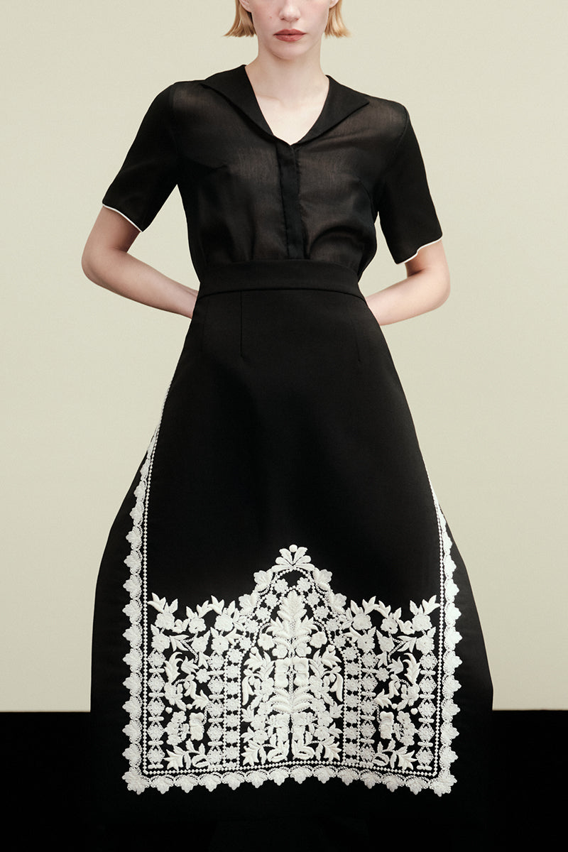DELEGAN PLAKHTA FILIGREE midi skirt in lightweight fabric with intricate lace details, styled for a modern, elegant look.