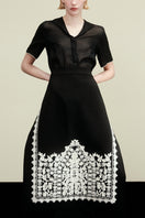Delegen PLAKHTA filigree midi skirt with intricate lace detailing, shown in a stylish campaign photo.