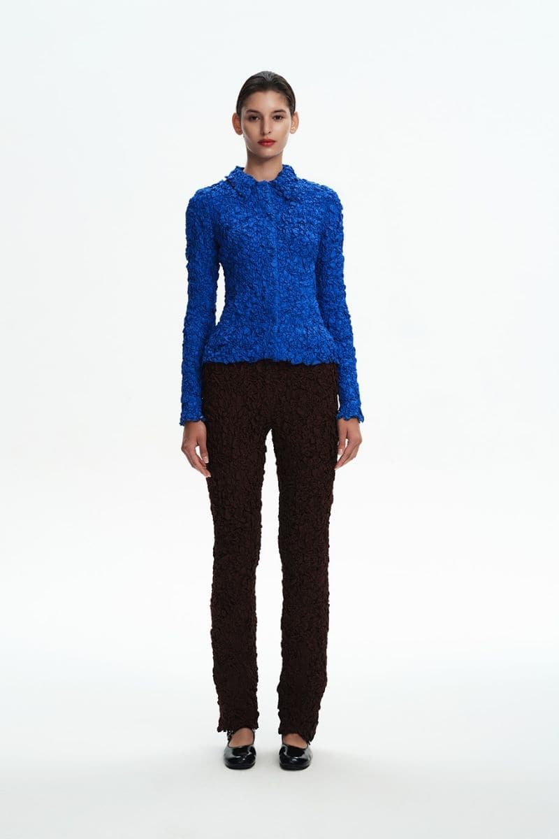 Navy blue smocked shirt by Chictopia with long sleeves and a fitted, textured bodice on a plain background.