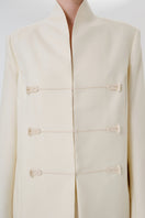 Dark-colored still form blazer by DELEGAN, showcasing sleek tailored design and stylish lapel detail.