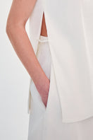 Close-up of the DELEGAN structural milk-colored top showing fabric texture and detailed stitching.