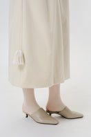 Close-up of a DELEGAN ivory velvet coat showing soft fabric texture and elegant design details.
